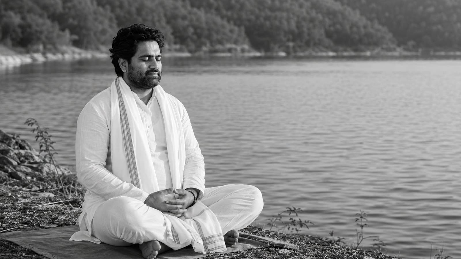 Dr. D.P. Shukla meditating cross-legged beside a still lake